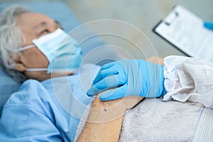 Doctor using stethoscope to checking Asian senior or elderly old lady woman patient wearing a face mask in hospital for protect