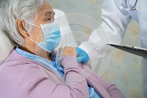 Doctor using stethoscope to checking Asian senior or elderly old lady woman patient wearing a face mask in hospital for protect