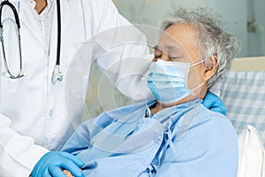 Doctor using stethoscope to checking Asian senior or elderly old lady woman patient wearing a face mask in hospital for protect