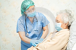 Doctor using stethoscope to checking Asian senior or elderly old lady woman patient wearing a face mask in hospital for protect