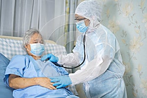 Doctor using stethoscope to checking Asian senior or elderly old lady woman patient wearing a face mask in hospital for protect