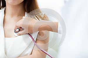 Doctor using stethoscope to exam woman