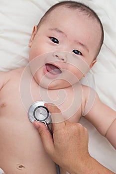 Doctor using a stethoscope to listen to baby`s chest