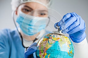 Doctor using a stethoscope to listen to the planet Earth globe and set diagnosis