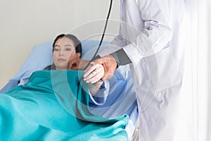 Doctor using stethoscope to woman patient for listening heart rate on sickbed at hospital,Selective focus hand