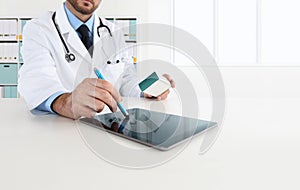 Doctor using tablet on desk office prescribes the medicine photo
