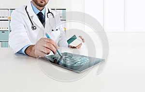 Doctor using tablet on desk prescribes medicine