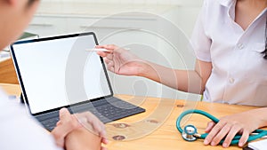 Doctor using tablet discussion something with patient