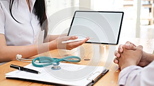 Doctor using tablet discussion something with patient