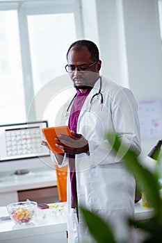 Doctor using tablet while searching for some information