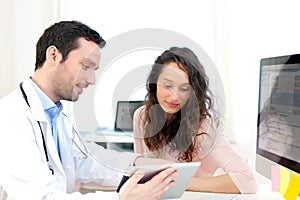 Doctor using tablet to inform patient photo