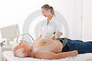 Doctor Using Ultrasound Scan On Abdomen Of Male Patient photo