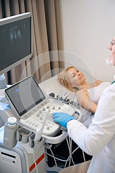 Doctor using ultrasound scan examining pretty woman