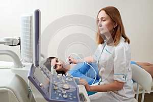 Doctor using ultrasound scanning machine examining female neck