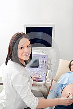 Doctor using ultrasound and screening pregnant woman.