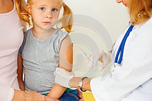 Doctor vaccinating small girl