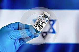 Doctor with a vial with 3rd dose of the vaccine for covid-19 or Coronavirus in front of the Israelite flag
