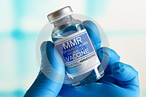 Doctor with vial of the doses vaccine for MMR Measless, Mumps and Rubella diseases. Medicine and health care concept photo