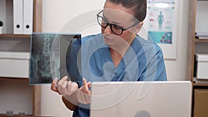 doctor video call, displaying X-ray films to laptop, and elucidating to the patient telemedicine.