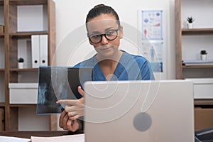 doctor video call, displaying X-ray films to laptop, and elucidating to the patient telemedicine.