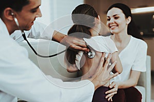 Doctor Visiting Little Girl in Red Scarf with Cold