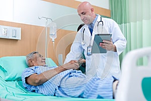 Doctor Visiting man Patient On Ward. Hospitalized man lying in bed while doctor checking his. physician examining male patient in