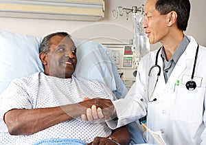 Doctor Visiting Senior Male Patient On Ward photo