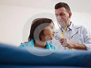 Doctor visiting sick young asian boy in hospital