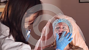 Doctor waits while the anesthesia on a nasolabial folds will act to make a nyxis