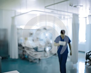 Doctor walking in the ICU, unfocused background