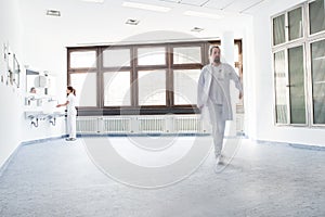 doctor walking through the room and nurse washing hands