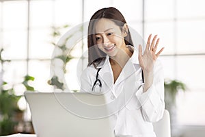 Doctor watching laptop computer and having video conference at clinic