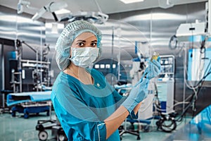 doctor wearing blue uniform with glove full virus protection holding syringe with medicine