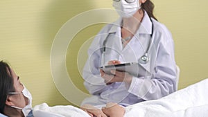 Doctor wearing face mask proficiently talks with patient at hospital ward