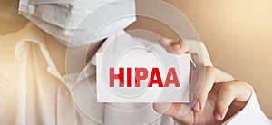 Doctor wearing face mask shows a card with text HIPPA. Health Medical concept. photo