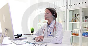 Doctor wearing a headset conducts online consultation with patient
