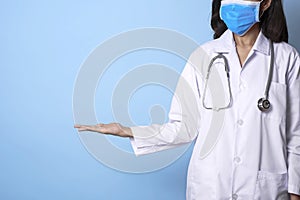 Doctor wearing mask covering mouth and nose and gesture hand point to copy space