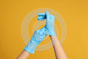 Doctor wearing medical gloves on background, closeup