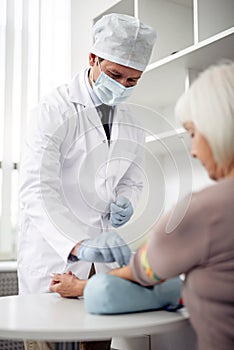 Doctor wearing medical mask and making injection