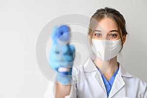 Doctor wearing protective mask using infrared thermometer to check temperature