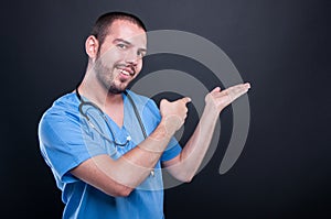 Doctor wearing scrubs with stethoscope holding copypsace and poi photo