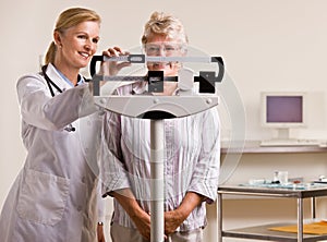 Doctor weighing senior woman in doctor office photo