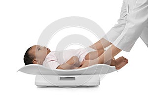Doctor weighting African-American baby on scales