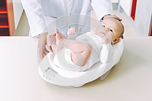 Doctor weighting cute baby at home