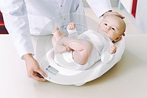 Doctor weighting cute baby at home