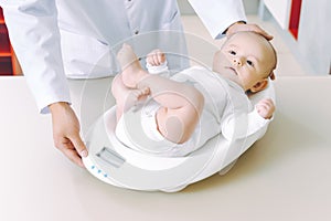 Doctor weighting cute baby at home