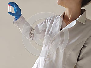 A doctor which dress a blue glove with a test tube