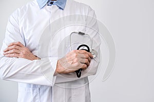 doctor in white coat with crossed arms and stethoscope