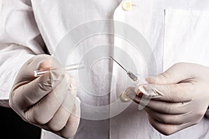 Doctor in a white coat and gloves holds opens a syringe close-up. vaccination an injection treatment cold flu measles covid-19