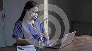 Doctor wipes with napkin the computer keyboard. Woman cleans the working surface with a disinfectant liquid or solution